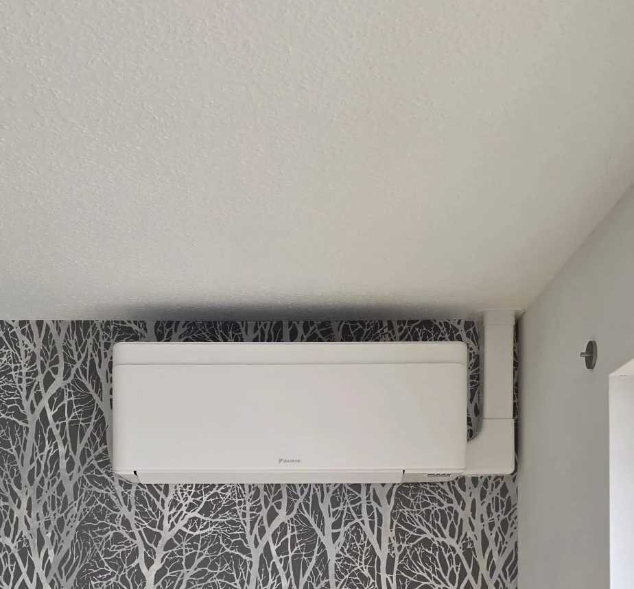 Weißes Daikin Stylish Innengerät vor einer gemusterten Tapete