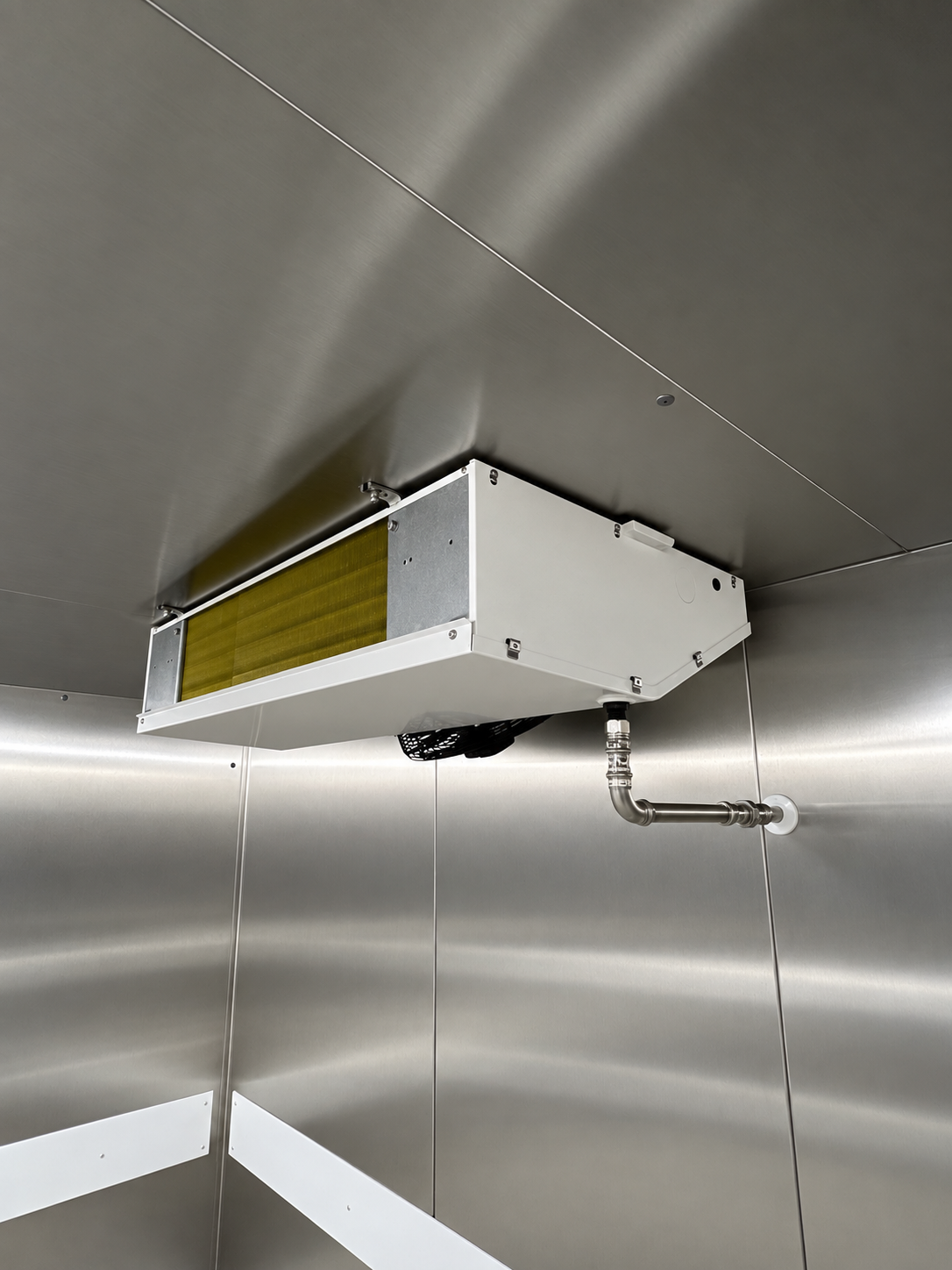 Deckenmontierter Verdampfer im Kühlraum mit angeschlossener Ablaufleitung.